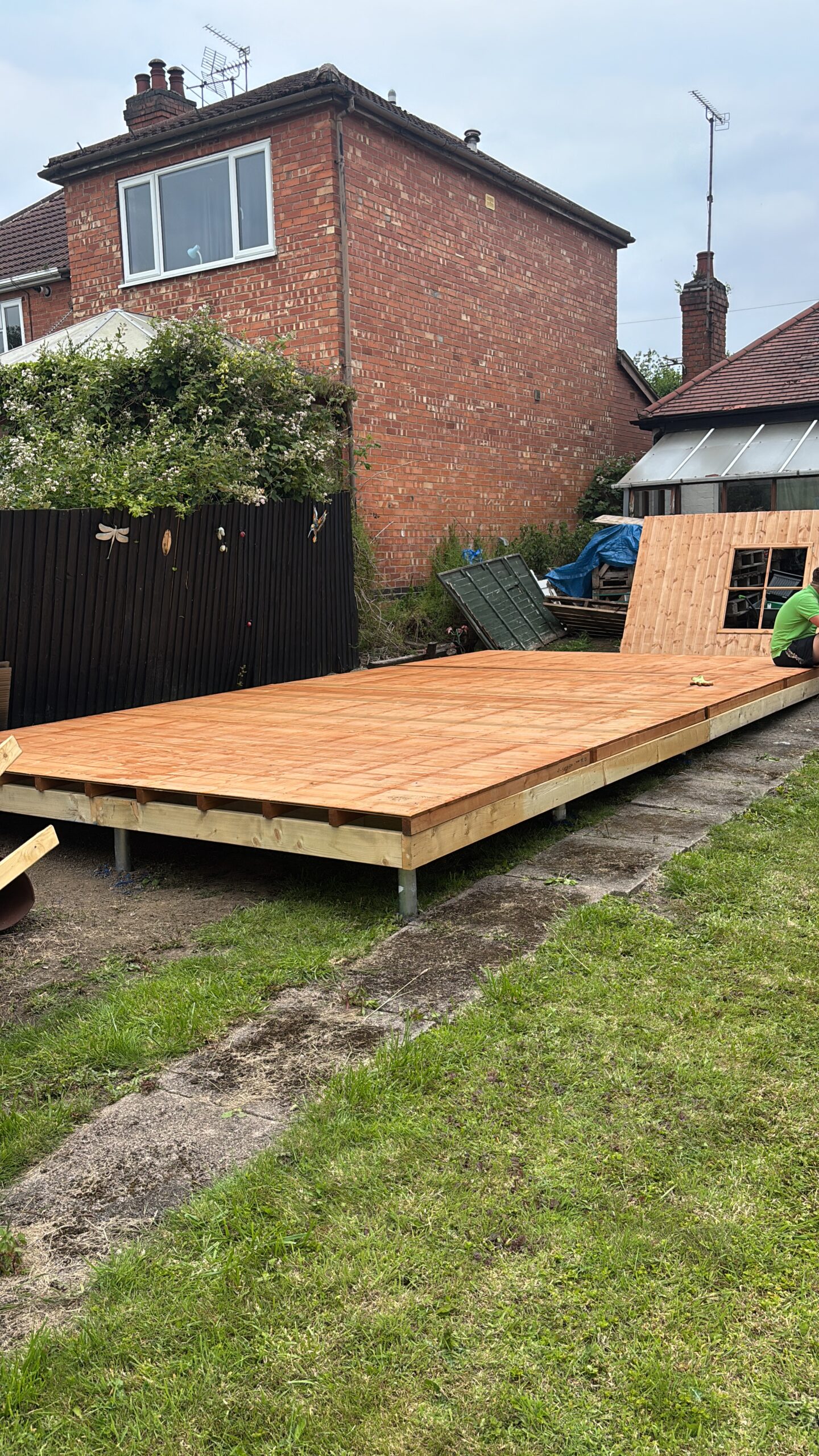 Completed shed sitting perfectly level on ground screws in a sloped garden