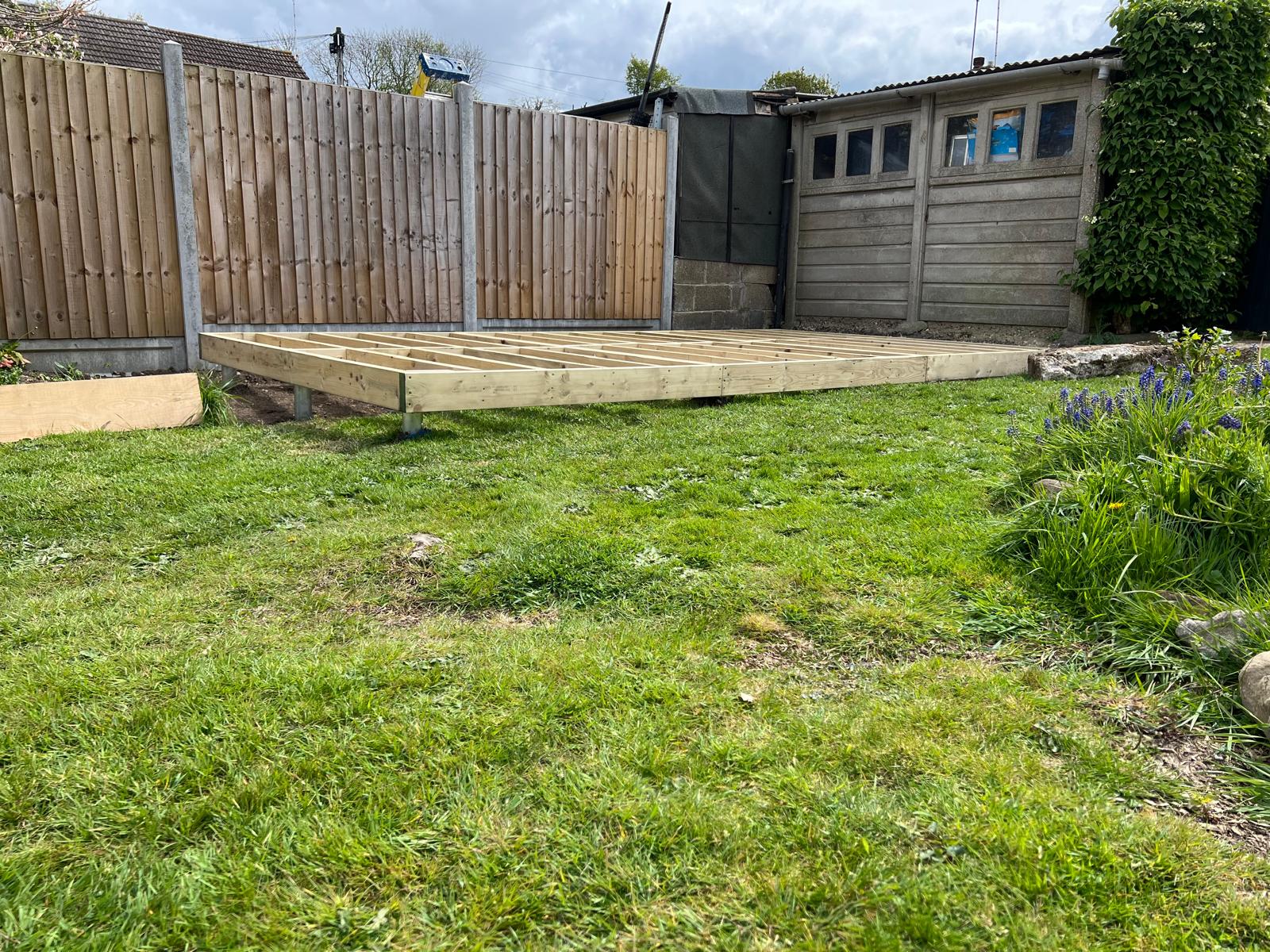 Ground screws installed on a sloped garden showing height difference between uphill and downhill screws
